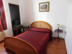 Schlafzimmer mit einem Bett mit einer roten Tagesdecke in der Unterkunft Passerelle Opéra Perpignan in Perpignan
