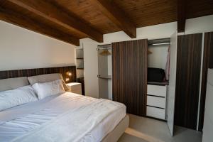 a bedroom with a large white bed and a closet at Mansarda Monache (M&M) in Bitetto