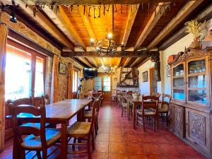 uma sala de jantar com mesas e cadeiras e um lustre em HOTEL RURAL LA HUERTA em Montejo de la Vega de la Serrezuela