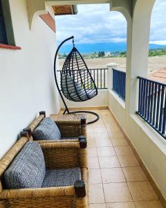 a porch with two wicker chairs and a swing at Lifestyle Villas, Nanyuki in Nanyuki