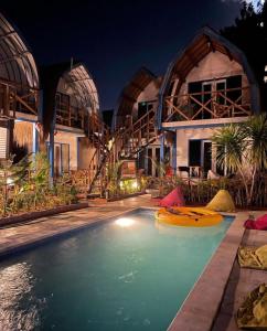 a house with a swimming pool with a boat in it at Tropical House Bungalows in Gili Trawangan