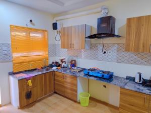 a kitchen with wooden cabinets and a counter top at Highly Secured 24 Hours Electricity Apartment in Garki