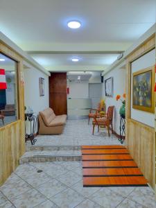 a lobby with a couch and a table and chairs at Hostal Solari in Trujillo