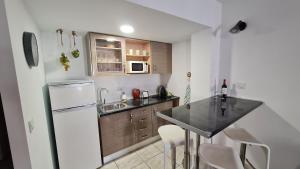 a small kitchen with a counter and a refrigerator at TREBOL Apartamentos Benalmádena in Arroyo de la Miel