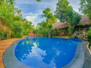 una piscina en un complejo con agua azul en Habarana Tree house Mutu village en Habarana