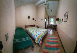 a bedroom with a bed with a colorful blanket at Fazenda Serra que Chora - Pousada e Restaurante in Itanhandu