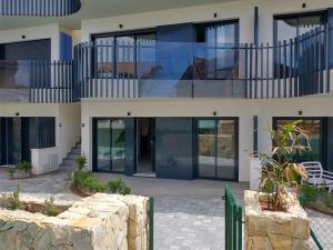 a building with glass doors and a stone wall at Modern nieuwbouwappartement aan het strand van de Mar Menor in Santiago de la Ribera in Lo Pagán