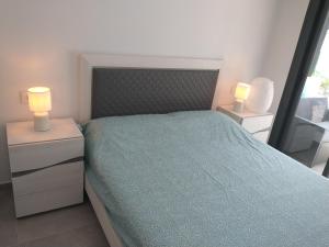 a bedroom with a bed and two lamps on night stands at Modern nieuwbouwappartement aan het strand van de Mar Menor in Santiago de la Ribera in Lo Pagán +35 photos