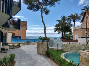 une passerelle à côté d'une maison avec un palmier dans l'établissement Modern nieuwbouwappartement aan het strand van de Mar Menor in Santiago de la Ribera, à Lo Pagán