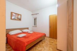 um quarto com uma cama com duas almofadas em Apartments by the sea Mandre, Pag - 205 em Kolan
