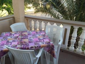 a table and chairs on a balcony with a quilt on it at Apartments by the sea Stara Novalja, Pag - 234 in Stara Novalja