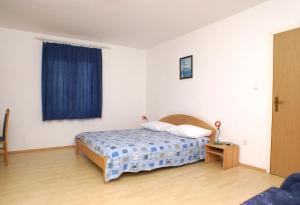 sypialnia z łóżkiem i niebieską zasłoną w obiekcie Apartments with a parking space Povljana, Pag - 229 w mieście Povljana