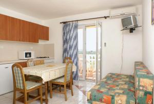 kuchnia i jadalnia ze stołem i krzesłami w obiekcie Apartments with a parking space Povljana, Pag - 229 w mieście Povljana