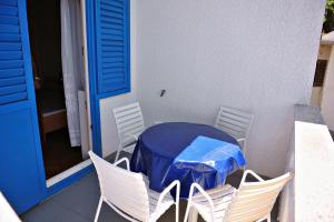 un tavolo blu con sedie bianche e una tovaglia blu di Rooms by the sea Metajna, Pag - 206 a Zubovići