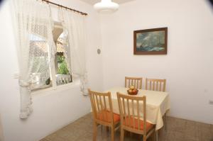a dining room with a table and chairs and a window at Apartments by the sea Simuni, Pag - 236 in Kolan