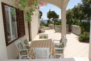 a table and chairs on a patio with a view of the ocean at Apartments by the sea Simuni, Pag - 236 in Kolan