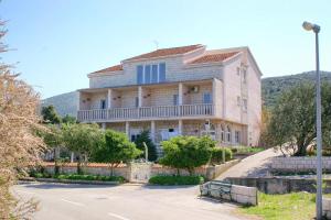 a large building with a bench in front of it at Apartments by the sea Kneza, Korcula - 167 in Račišće