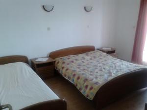 ein Schlafzimmer mit einem Bett und zwei Nachttischen in der Unterkunft Apartments by the sea Kneza, Korcula - 167 in Račišće