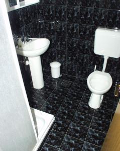 a black tiled bathroom with a toilet and a sink at Apartments by the sea Kneza, Korcula - 167 in Račišće