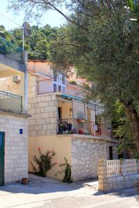 un edificio de apartamentos con balcón y un árbol en Apartments by the sea Brna, Korcula - 171, en Smokvica