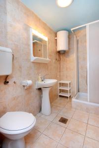 Un baño con inodoro, lavabo y ducha. en Apartments by the sea Brna, Korcula - 171, en Smokvica