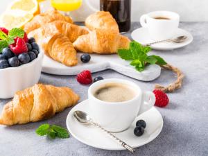 a table with cups of coffee and croissants and berries at Holiday Inn - St Augustine - World Golf, an IHG Hotel in Saint Augustine