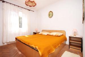 a bedroom with a bed with a yellow blanket on it at Apartments by the sea Vela Luka, Korcula - 159 in Vela Luka