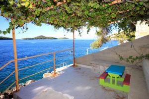 a colorful bench sitting on a porch overlooking the water at Apartments by the sea Prizba, Korcula - 176 in Prizba