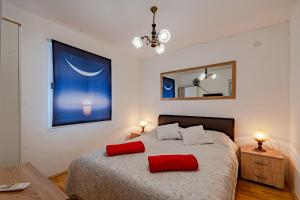 a bedroom with a bed with two red pillows on it at Apartments by the sea Prigradica, Korcula - 248 in Blato