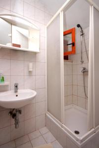 biała łazienka z umywalką i prysznicem w obiekcie Apartments by the sea Korcula - 157 w Korčuli