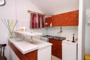 Elle comprend une petite cuisine avec des placards blancs et un évier. dans l'établissement Apartments by the sea Korcula - 157, à Korčula