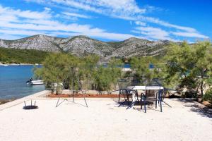 a table and chairs on the beach with a view of the water at Apartments by the sea Kneza, Korcula - 168 in Račišće