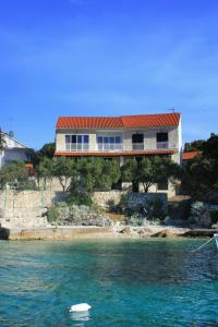 ein Haus auf einem Hügel neben dem Wasser in der Unterkunft Apartments by the sea Tri Zala, Korcula - 174 in Korčula