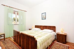 a bedroom with a large bed and a window at Apartments by the sea Grscica, Korcula - 169 in Prizba
