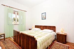 sypialnia z dużym łóżkiem i oknem w obiekcie Apartments by the sea Grscica, Korcula - 169 w mieście Prižba