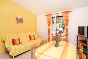 a living room with a yellow couch and a table at Apartments by the sea Grscica, Korcula - 169 in Prizba