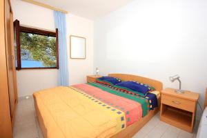 Schlafzimmer mit einem Bett und einem Fenster in der Unterkunft Apartments by the sea Tri Zala, Korcula - 174 in Korčula