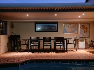 a bar with chairs next to a swimming pool at Africatamna Self Catering House in Durban