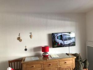 ein Wohnzimmer mit einem TV und einer Holzkommode in der Unterkunft Les toits de dévoluy in Le Dévoluy