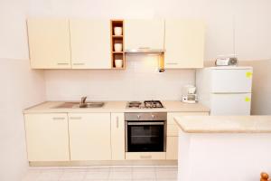 a white kitchen with a sink and a refrigerator at Apartments by the sea Zavalatica, Korcula - 189 in Zavalatica +31 photos