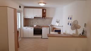 a kitchen with white cabinets and a white refrigerator at Apartments by the sea Zavalatica, Korcula - 189 in Zavalatica
