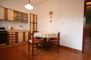 eine Küche mit einem Tisch und Stühlen im Zimmer in der Unterkunft Apartments with a parking space Povljana, Pag - 226 in Povljana