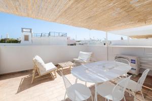 a patio with a table and chairs on a roof at Travessa's House in Olhão