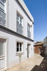 a white house with windows and a courtyard at Travessa's House in Olhão