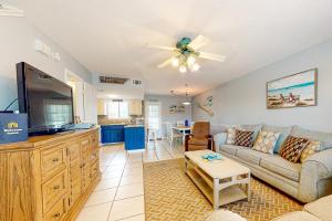 a living room with a couch and a flat screen tv at Gulf Highlands - 173 Damon Circle in Panama City Beach