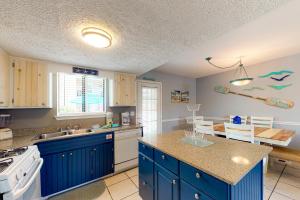 a kitchen with blue cabinets and a counter top at Gulf Highlands - 173 Damon Circle in Panama City Beach