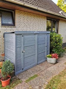 a blue shed in front of a house at Ferienwohnung Prange Cuxhaven in Cuxhaven