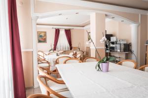 a dining room with a white table and chairs at Kaiser Panzió in Baja