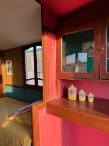 a small room with a bed and a window at La Roulotte Bohème des Grillots in Beaulon