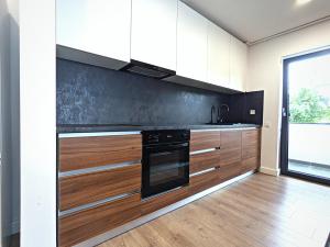 a kitchen with white cabinets and a black oven at Ira Premium Apartment Cluj in Cluj-Napoca